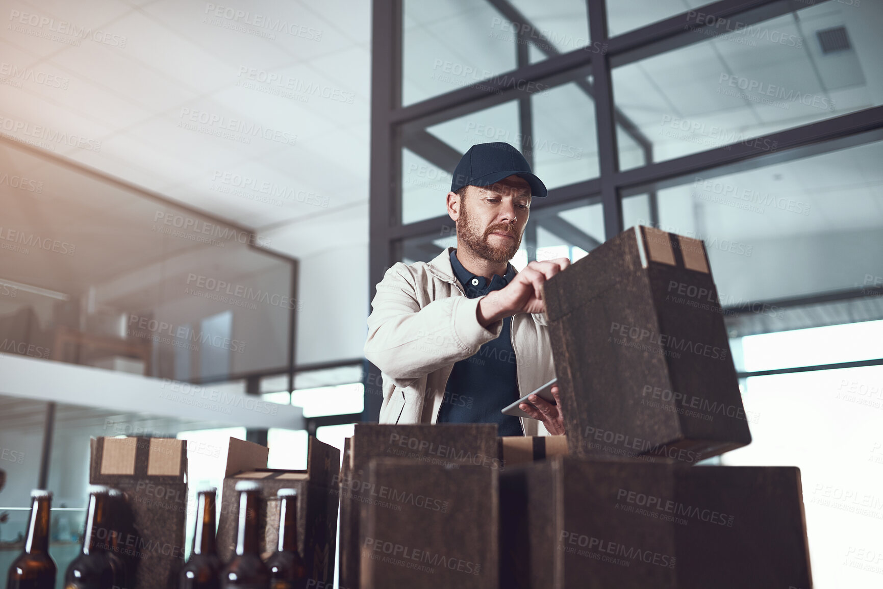 Buy stock photo Courier, tablet and boxes in warehouse with check for beer, stock and inventory for Oktoberfest in Munich. Man, storage and packaging for delivery with alcohol, touchscreen and app for supply chain