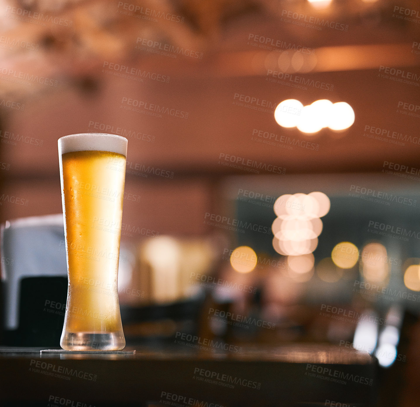 Buy stock photo Glass, foam and cold beer in pub for drinks as draft from pint with craft, fresh or smooth taste. Weizen, bubbles and golden, alcohol and lager from brewery in restaurant for celebration in Germany