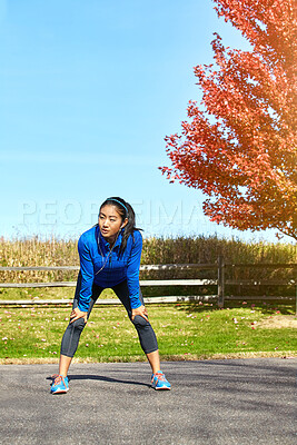 Buy stock photo Asian woman, runner and break with earphones for audio, rest or music after workout or outdoor training in countryside. Female person or athlete in recovery or breathing for cardio exercise in nature