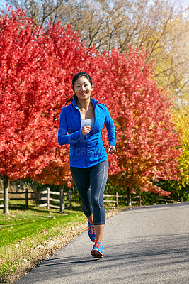 Buy stock photo Nature, asian woman and running with fitness and happy for cardio workout, training or outdoor exercise in countryside. Active female person, athlete or runner with smile for sprint on road in autumn