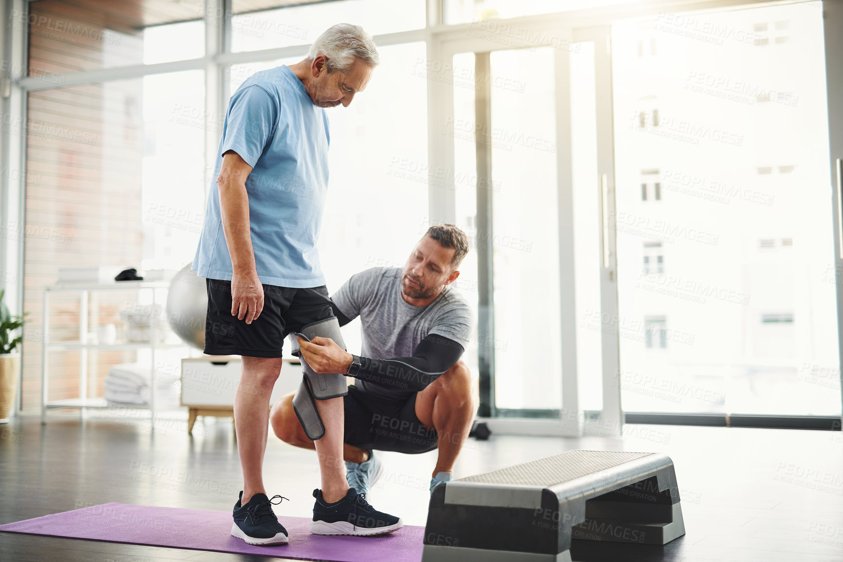 Buy stock photo Senior, man and physiotherapist with knee bandage for support, circulation or compression for healing. Fitness, physiotherapy and elderly person with joint wrap, mobility training and exercise in gym