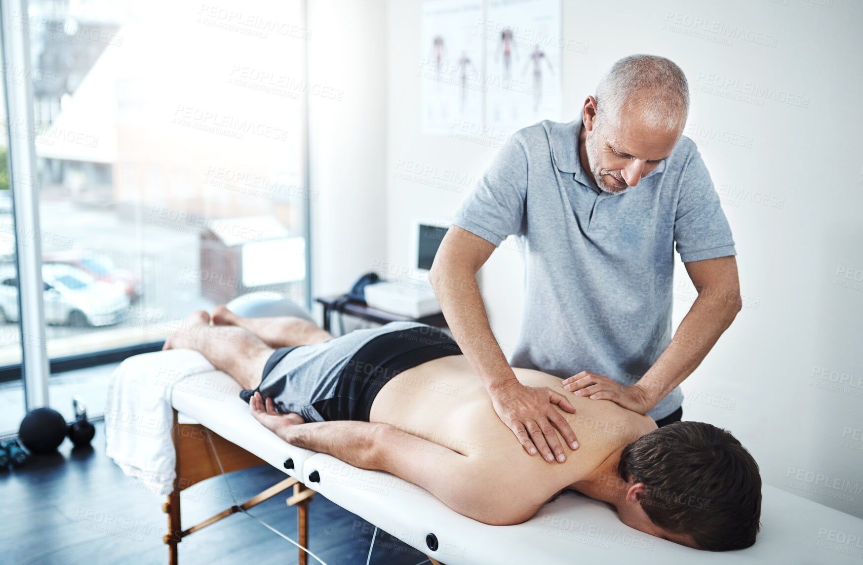 Buy stock photo Man, spine pain and physiotherapist working in consulting, rehabilitation with exercise for wellness. Male people, office and together for physiotherapy service with health insurance or support