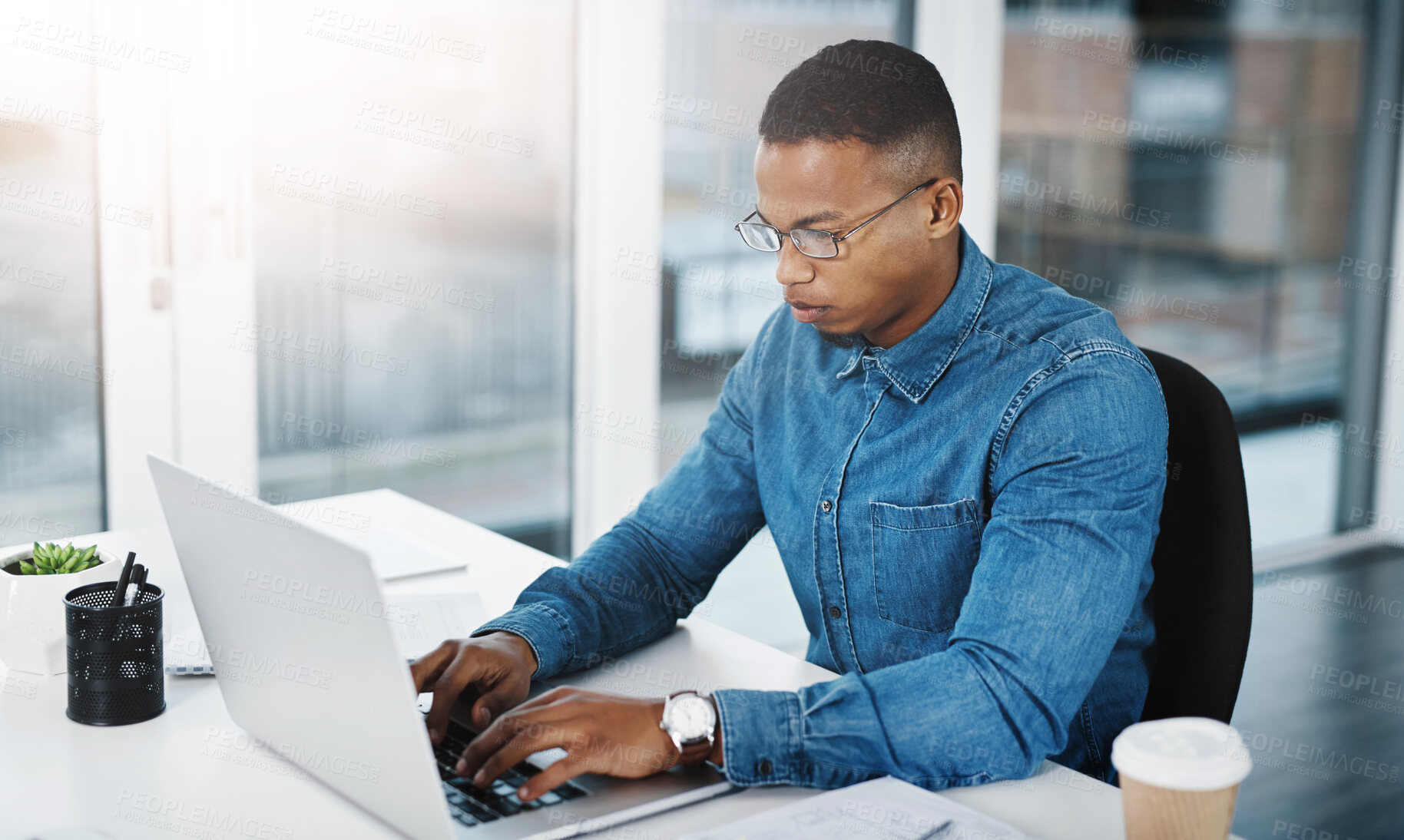 Buy stock photo Typing, serious and black man by computer in office, workspace or desk professional in creative career. Email, internship or journalist with technology for productivity, research or internet