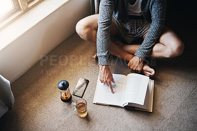 Buy stock photo Morning, man and reading book on floor for knowledge, entertainment or relax in living room. Lens flare, high angle and person with cup of tea for information, hobby or studying literature in home