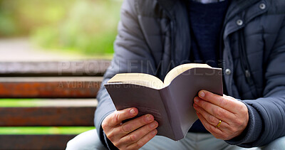 Buy stock photo Cropped shot of an unrecognizable elderly man reading a book by herself outside in a park