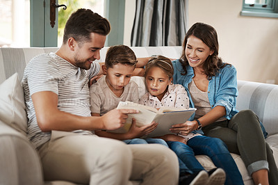 Buy stock photo Parents, children and book for story on sofa with care, bonding and happy for learning in family home. Father, mother and kids with love, connection and reading for development on couch in Madrid