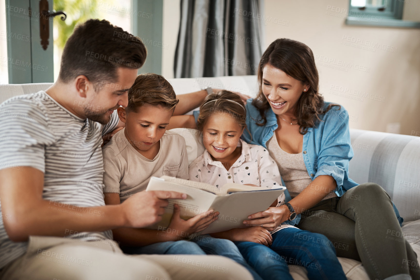 Buy stock photo Parents, children and book for story on couch with care, bonding and happy for learning in family home. Father, mother and kids on sofa with love, connection and reading with development in Madrid