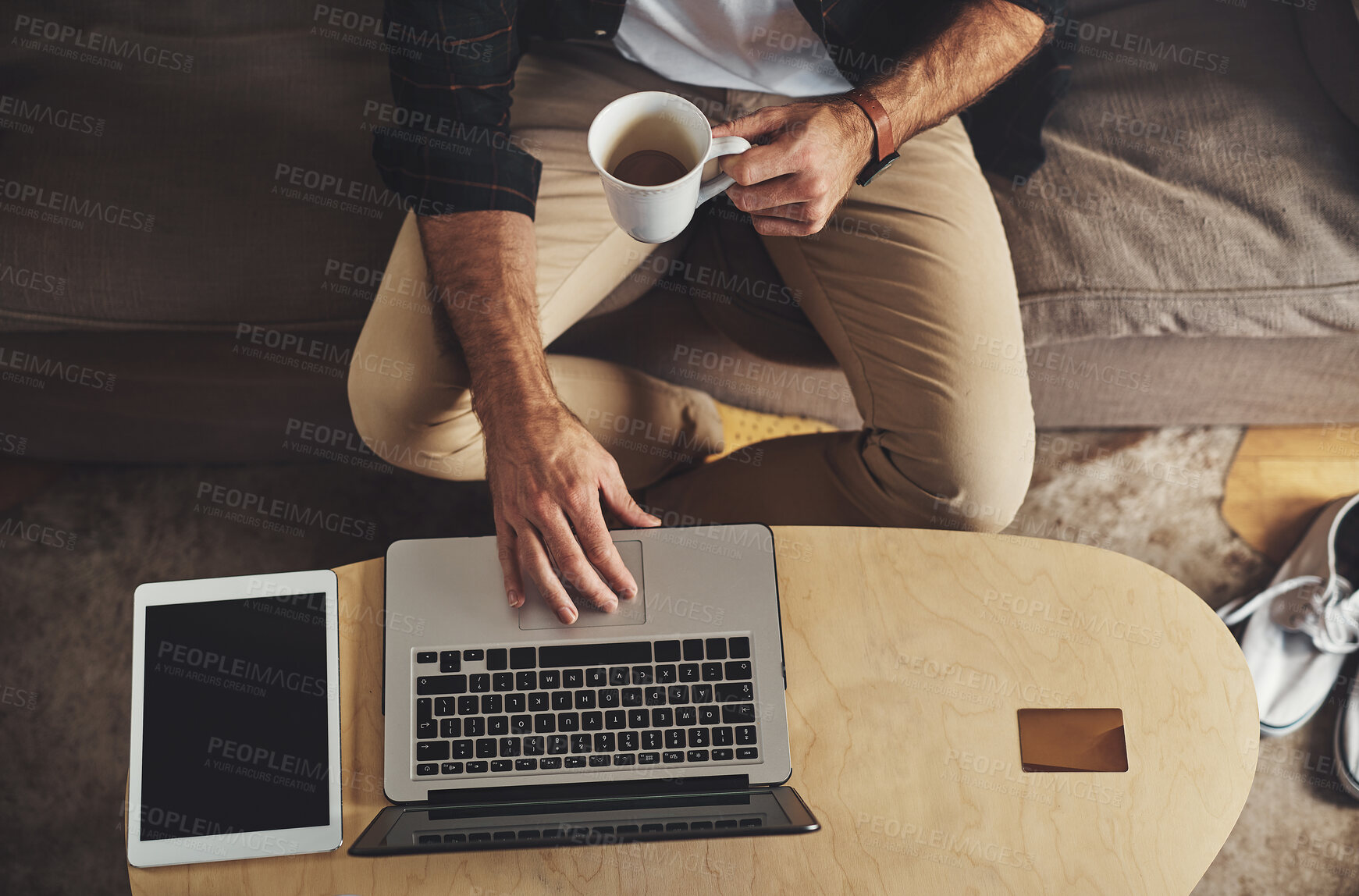 Buy stock photo Above, hands of man and tech in home for remote work, ecommerce and digital trade on internet. Laptop, coffee and person on sofa for research, company review and online feedback for small business