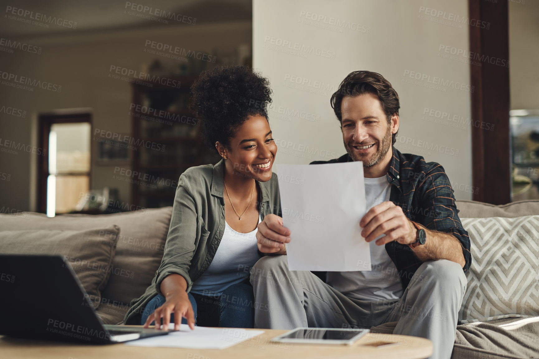 Buy stock photo Couple, paperwork and planning on sofa with laptop for online tax registration, insurance application and savings in home. Interracial lovers, computer and documents for finance, bills and loan form