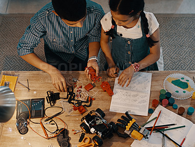 Buy stock photo Above, children and siblings with robotic toy, building or assembling for bonding, together and home. Girl, boy and teamwork for creativity, playful and learning with tools, parts and manual in house