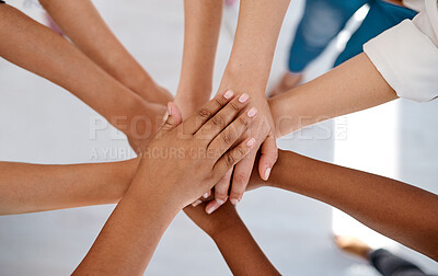 Buy stock photo Cropped shot of a group of unrecognizable businesspeople joining hands together in a huddle inside an office