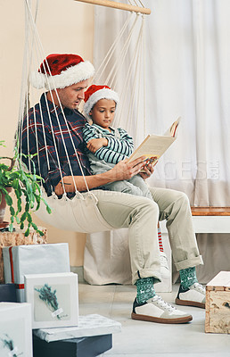 Buy stock photo Dad, son and reading with christmas story or book at home for festive novel in december. Father bonding with young child, kid or little boy for fairytale, chapter or childhood on weekend at house