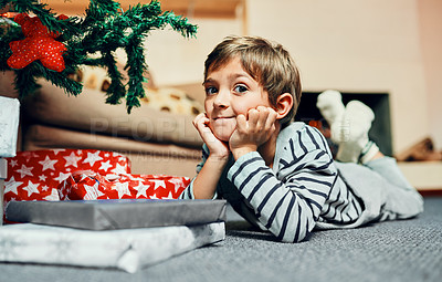 Buy stock photo Christmas tree, portrait and child waiting for gift to celebrate winter holiday, vacation or joyful event in home or house. Kid, development or boy lying on carpet to relax in xmas festive season