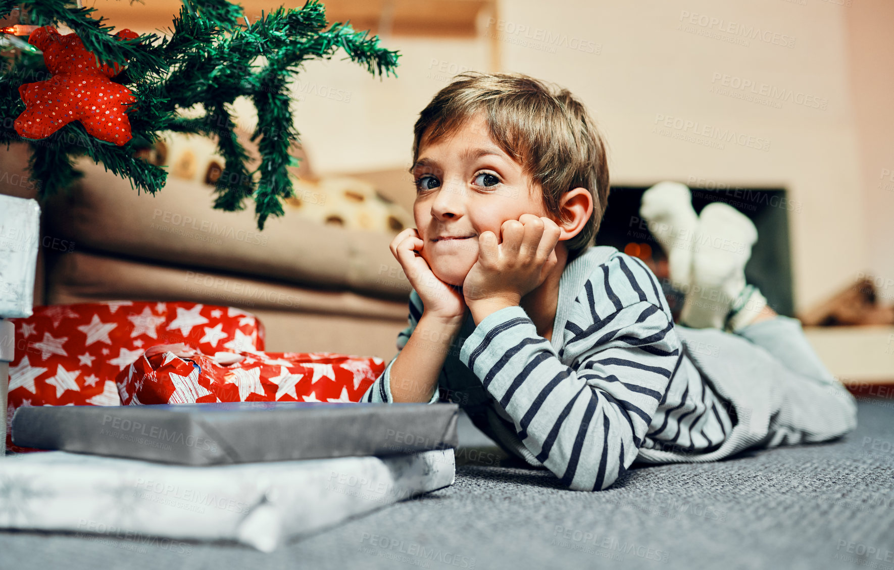 Buy stock photo Christmas tree, portrait and child waiting for gift to celebrate winter holiday, vacation or joyful event in home or house. Kid, development or boy lying on carpet to relax in xmas festive season