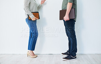 Buy stock photo Closeup shot of two unrecognisable businesspeople having a discussion while standing against a wall in an office