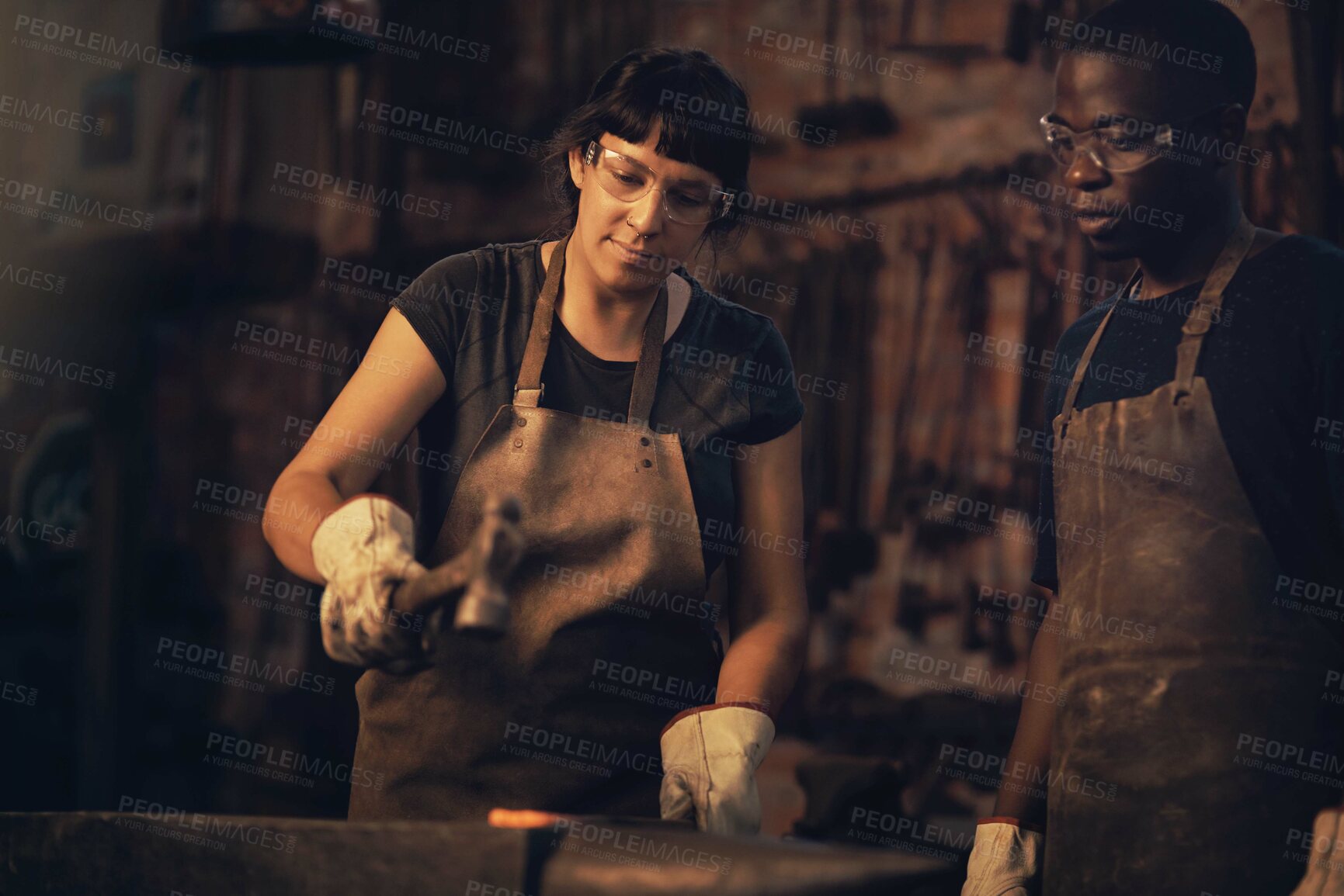 Buy stock photo Welding, confident and woman with smile, workshop and proud of gender equality in foundry and blacksmith. Hardworking, apron and manufacturing in factory, people and skills for collaboration with man