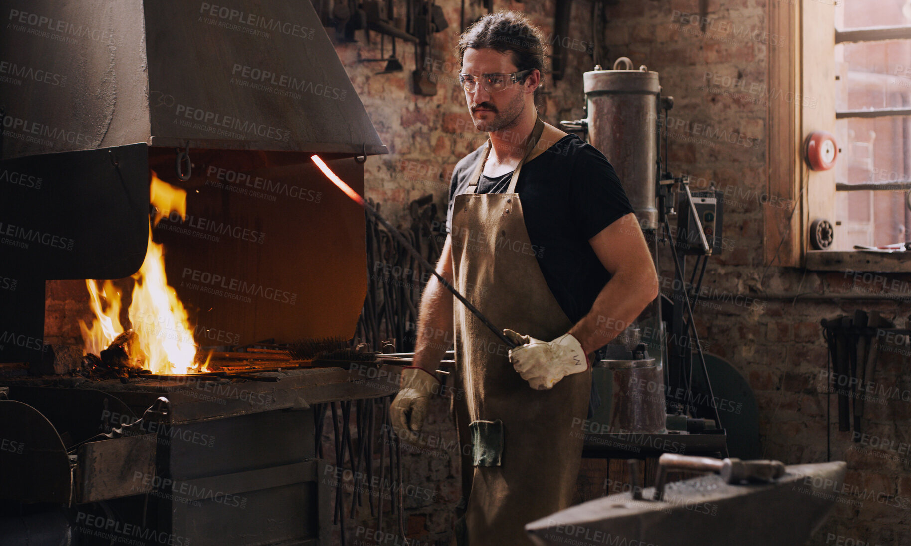 Buy stock photo Blacksmith, man and fire with metal rod, flame and equipment for professional craft. Protection, apron and gloves in workshop with anvil for metalwork, hammer and forge for iron product creation