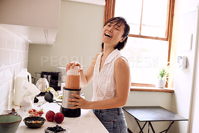 Buy stock photo Asian woman, happy and smoothie in kitchen of home for healthy breakfast, morning routine or body detox. Person, laughing and food mixer for organic drink, wellness and vegan diet or funny by counter