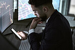 Stressed businessman using a smartphone, trading on the stock market in a financial crisis. Trader working online in a bear market with stocks crashing. Market crash and economy depression or failure