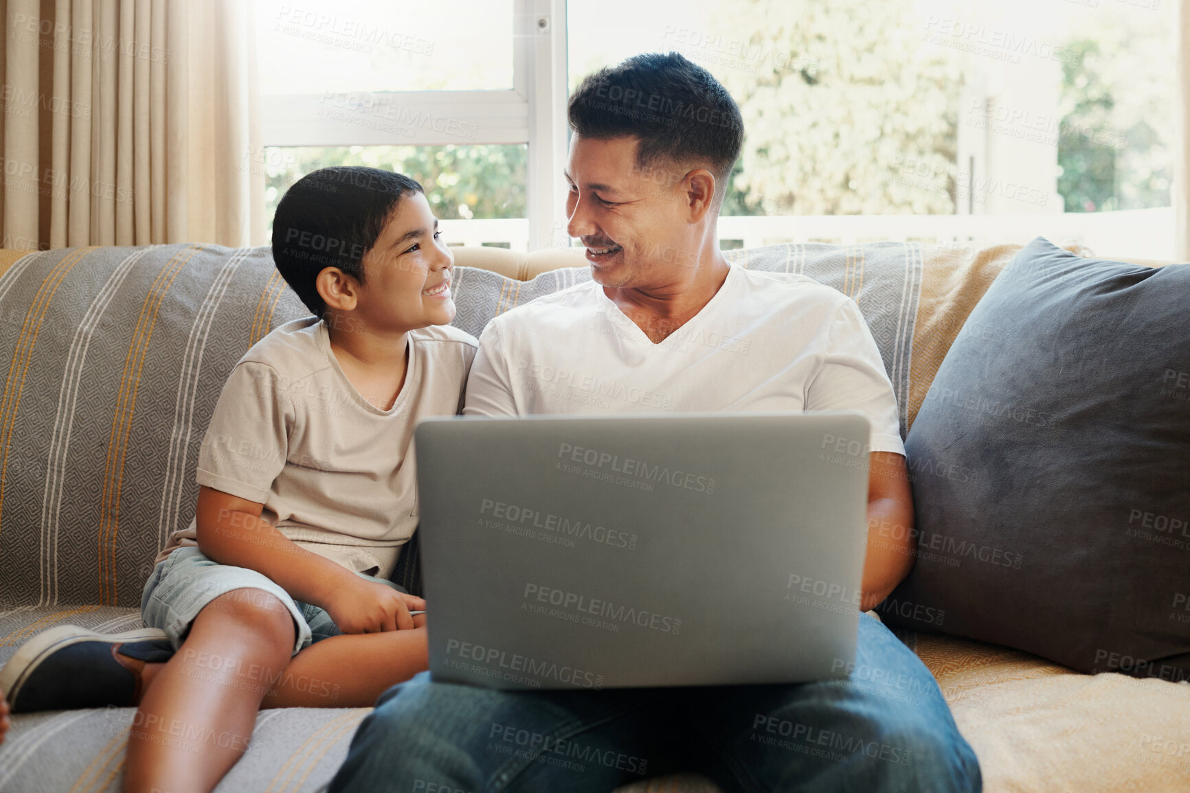 Buy stock photo Dad, boy and smile with laptop on sofa for streaming cartoon movies, entertainment videos and bonding. Father, child and relax in living room of home with technology for online gaming and connection.