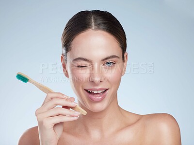 Buy stock photo Woman, portrait and wink with toothbrush in studio, dental care and oral hygiene for fresh breath. Girl, wellness and teeth whitening for cavities, gum health and gingivitis by white background