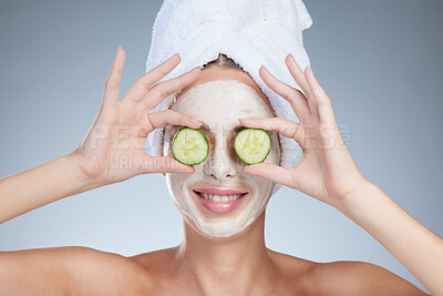 Buy stock photo Woman, cucumber eyes and face mask for beauty in studio, eco friendly and skincare on blue background. Female person, cosmetics and organic clay treatment to pamper, sustainable dermatology and detox