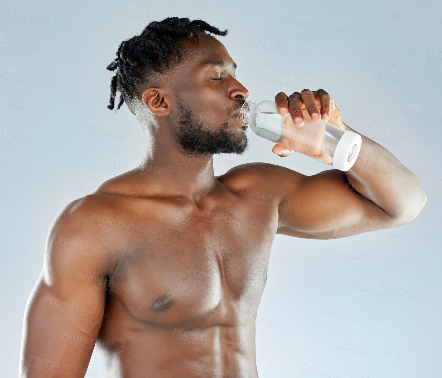 Buy stock photo Shirtless, black man and water for drinking in studio with body hydration and muscle development for confidence. African guy, thirsty bodybuilder and bottle for exercise break by white background