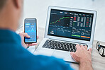 Closeup of a businessman using a phone and laptop, trading on the stock market in a financial crisis. Online trader with computer in a bear market. Virtual or remote work in market and economy crash