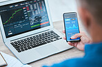 Closeup of a businessman using a phone and laptop, trading on the stock market in a financial crisis. Online trader with computer in a bear market. Virtual or remote work in market and economy crash