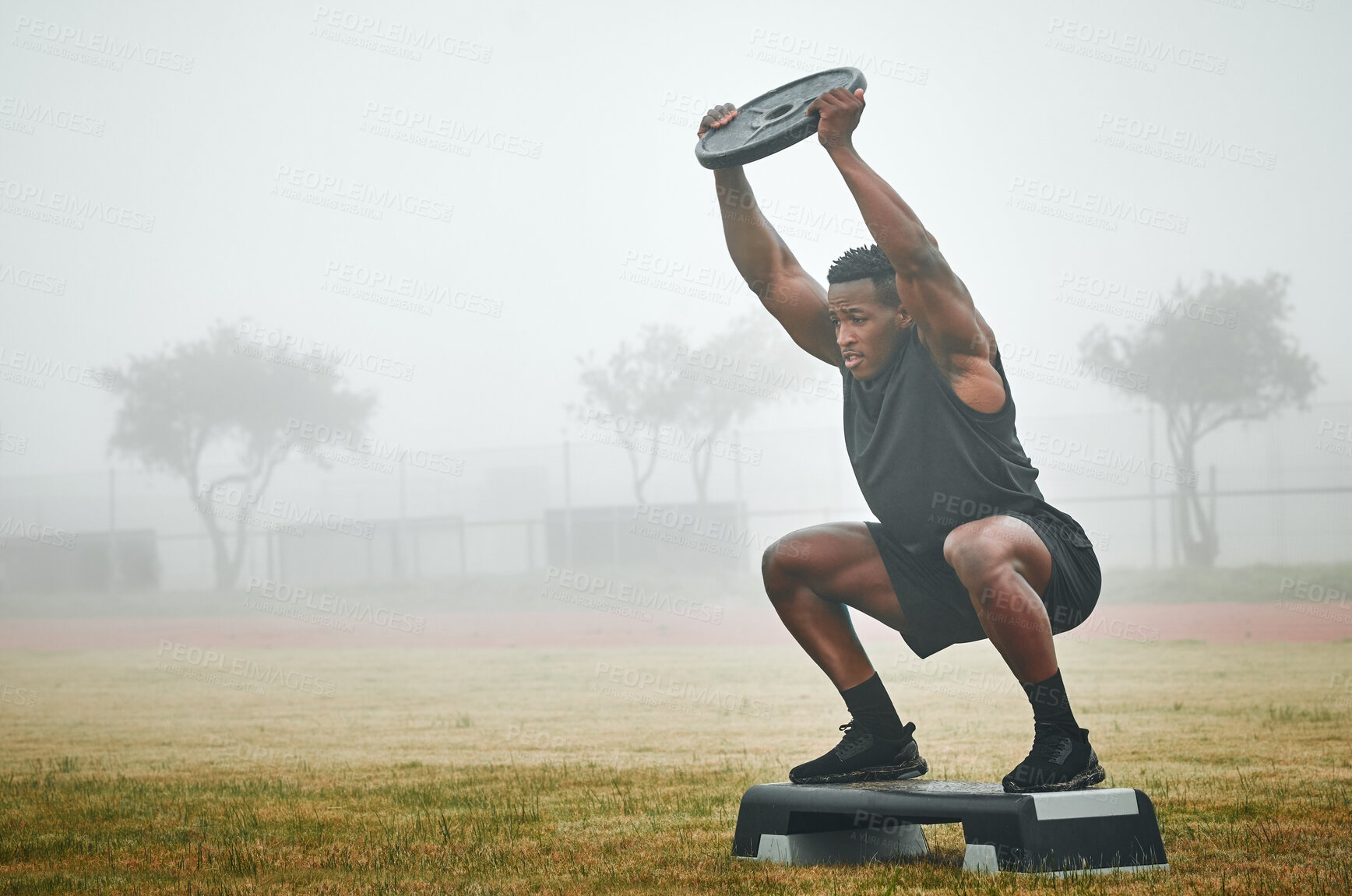 Buy stock photo Black man, exercise and weightlifting with squat, outdoor and step for balance with power for fitness. Person, bodybuilder and challenge with workout, development and training on field in Chicago