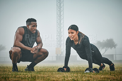 Buy stock photo Man, woman and coach with dumbbell on grass for pushup, balance and strong with motivation for wellness. Personal trainer, client and support with training, exercise and guide with plank on field