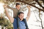 Happy caucasian father and son having fun and playing together outside. Carefree man carrying excited son on his shoulders while bonding in at the park. Single dad enjoying quality time with kid