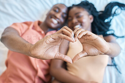 Buy stock photo Black couple, home and happy with hands in heart for bonding together, relationship and commitment. Face smile, African woman and man with love emoji on bed for care, marriage loyalty and kindness