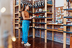 One beautiful asian female business owner standing with a clipboard in her cafe. Confident and successful mixed race woman taking stock in her restaurant. Making sure the coffee shop shelves are full