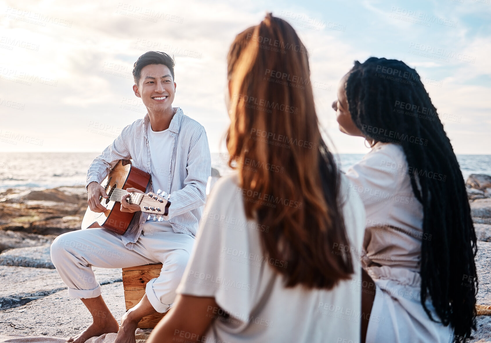 Buy stock photo Guitar, man and friends on beach for social, bonding and celebration in nature with music. Musician, instrument and entertainment on seaside with people, student gathering and reunion on vacation