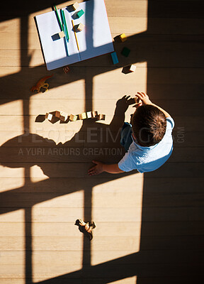 Buy stock photo Top view, child and blocks for learning in home, education and toys for playing in living room. Above, boy and toddler for creative activity to develop skills, games and cubes or books on floor