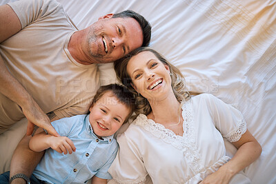 Buy stock photo Happy family, portrait and lying with child above on bed for bonding, holiday or weekend at home. Top view of mother, father and son with smile or relax in bedroom for morning, rest or joy at house