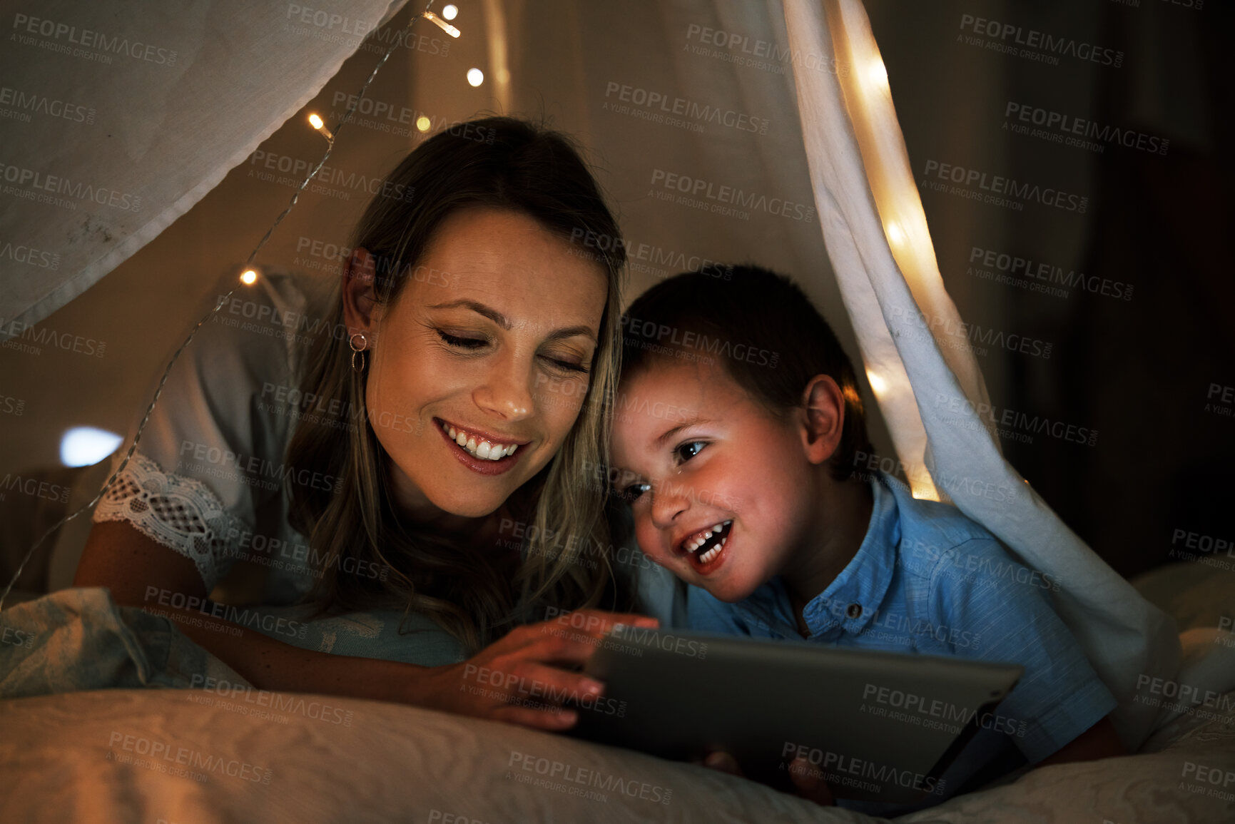 Buy stock photo Mother, boy and tablet in home at night, online and app for playing games or website for series. Mommy, son and blanket for fort or watching movie in bedroom, streaming and rest together in bed