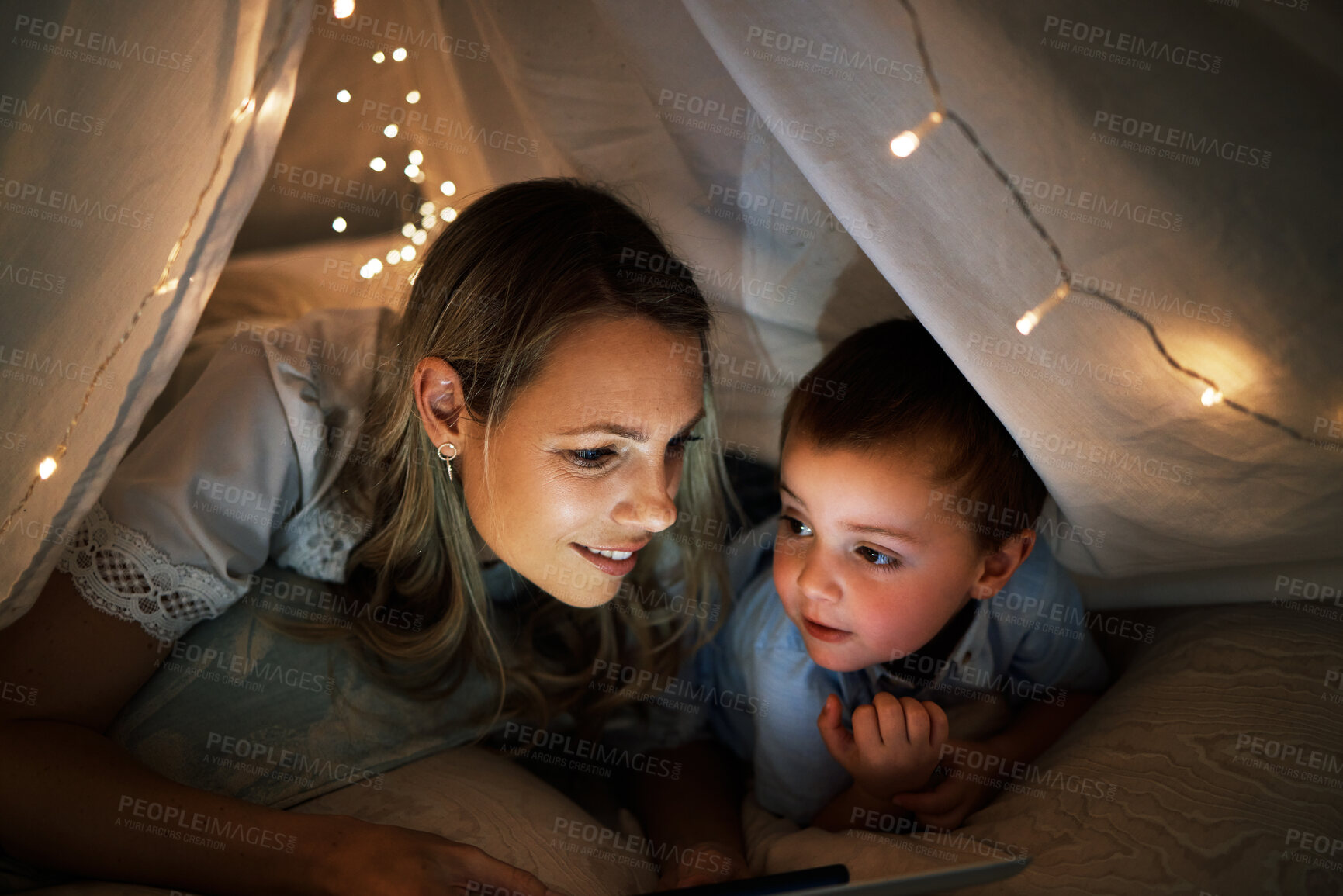 Buy stock photo Mother, boy and tablet in tent at night, online and app for playing games or website for series. Mommy, son and blanket for fort or watching movie in bedroom, streaming and rest together in home