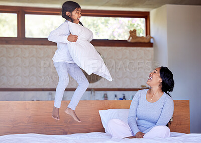 Buy stock photo Mom, girl and jump on bed in house for fun, development and bonding together with smile or laugh. Mother, child and game in bedroom for growth, wellness and care with pillow, happiness or playing