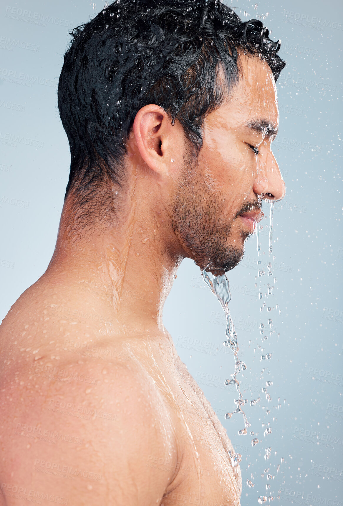 Buy stock photo Man, water and shower for body care in studio, bathroom and grooming on blue background. Male person, peace and liquid for skincare in profile, cosmetics and washing for hygiene or facial treatment