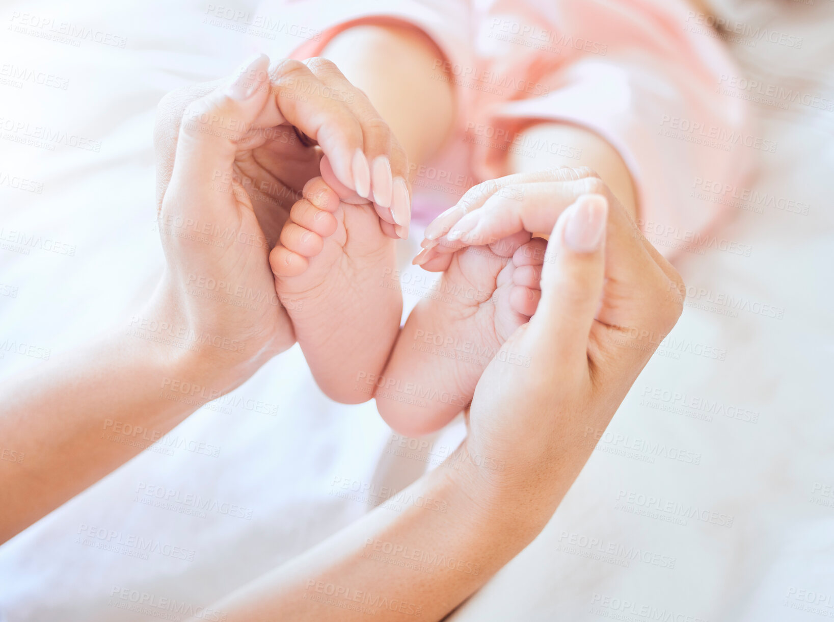 Buy stock photo Family, bed and hands with feet of baby for heart, bonding and loving relationship in home. Adorable, motherhood and parent holding infant toes in bedroom for love, child development and care