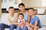 Portrait of a multiracial family at home. Mother with her adoptive sons. Young mother relaxing with her children. Mixed race family relaxing together at home. Boys spending time with their parent