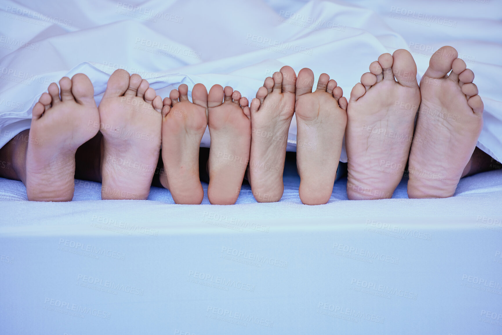 Buy stock photo Closeup, feet and family in bed, relax and bonding together with mattress comfort, morning and calm. Sleep, people and group in house, safety and secure with fun, playful and games with love and care