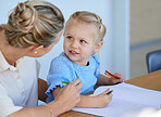 Adorable little girl learning to draw while mother helps her at home. Cute little girl learning how to read and write with tutor for kindergarten or preschool. Little girl drawing with colourful pencils 