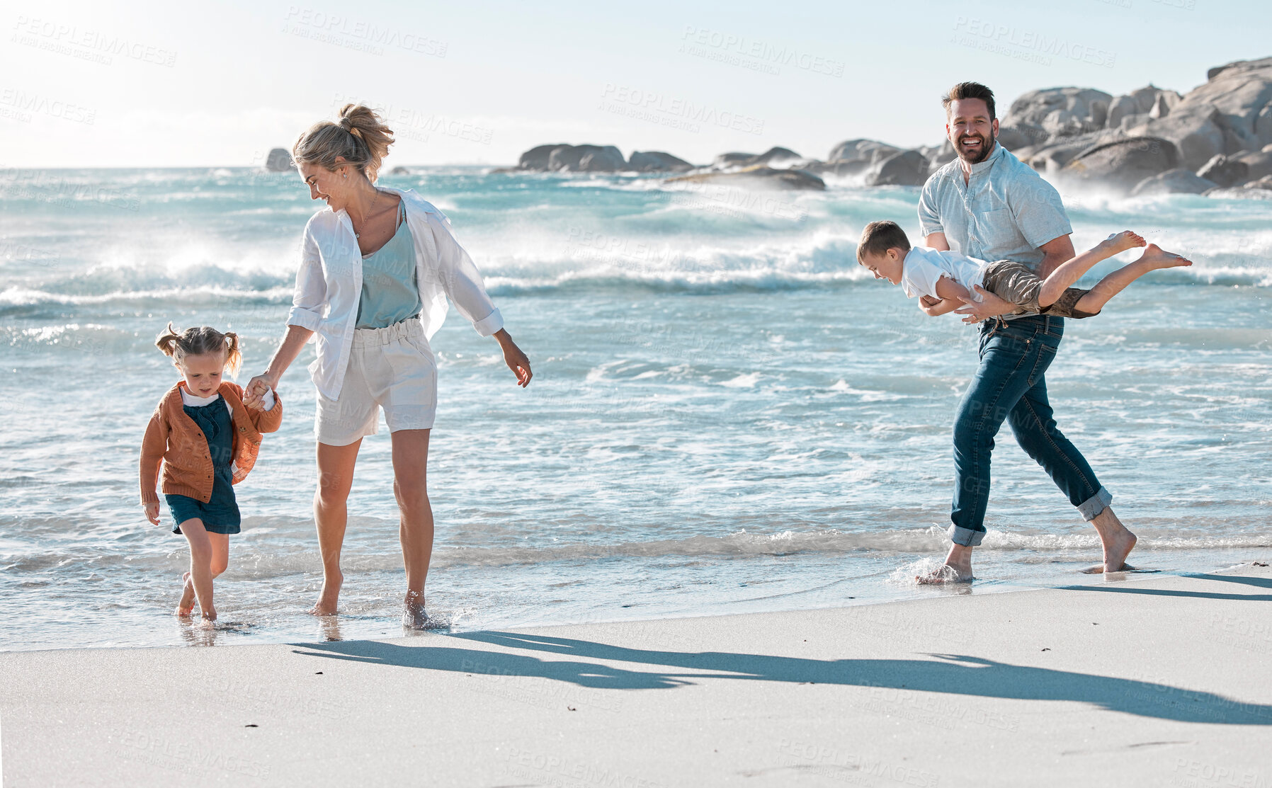 Buy stock photo Parents, children and playing on beach for holiday with bonding, fun walk and summer vacation. Happy family, couple and kids in water at ocean for getaway trip, travel and scenery with love and care