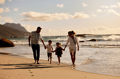 Buy stock photo Parents, children and holding hands for sunset at beach by waves, outdoor and connection on holiday. People, family and kids with clouds, love and bonding in nature for vacation by ocean in Italy