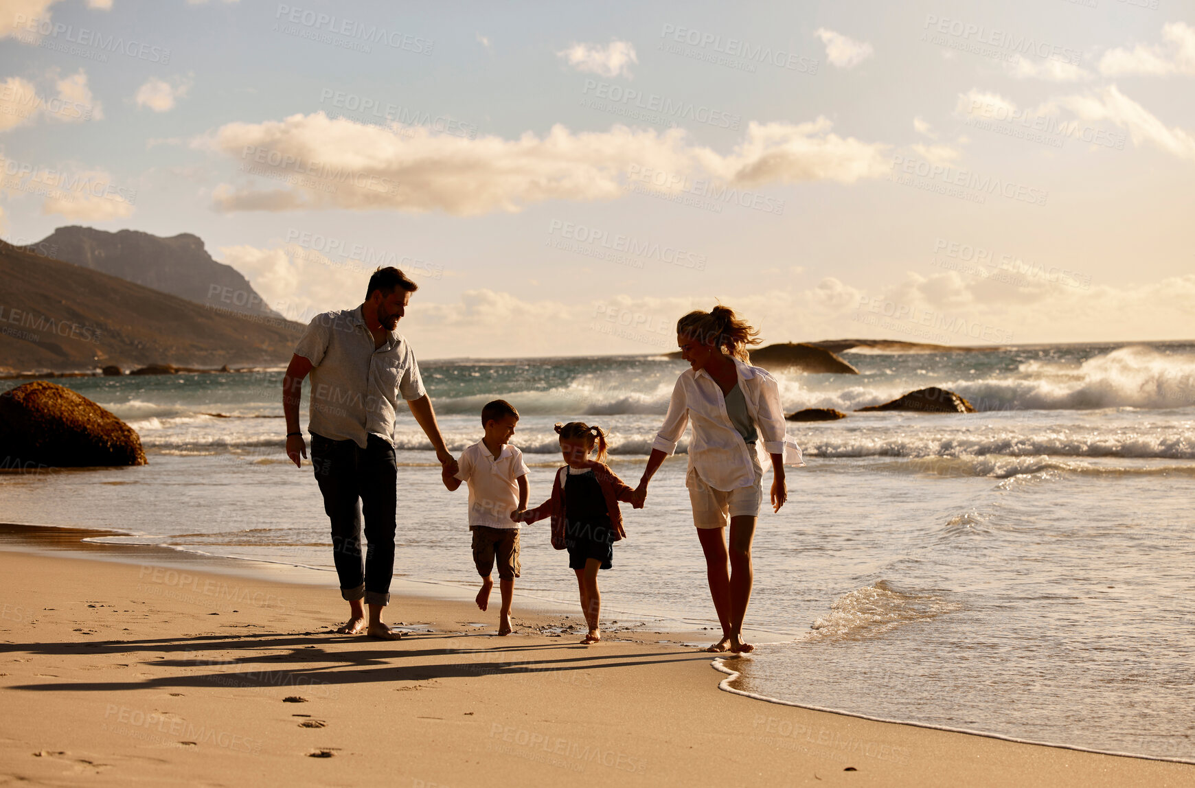 Buy stock photo Parents, children and holding hands for sunset at beach by waves, outdoor and connection on holiday. People, family and kids with clouds, love and bonding in nature for vacation by ocean in Italy