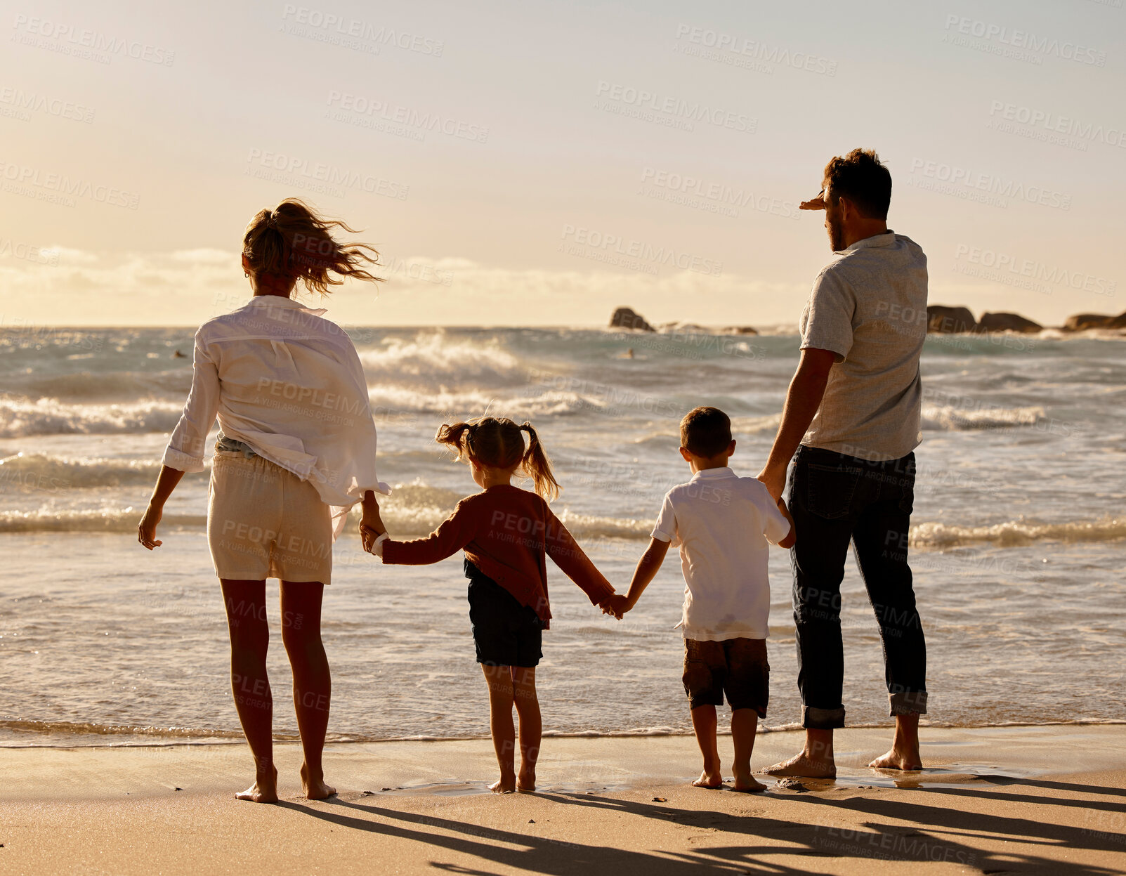 Buy stock photo Sunset, parents and kids holding hands on beach for holiday adventure together in tropical island waves. Mother, father and children on ocean vacation with travel, relax and family bonding from back