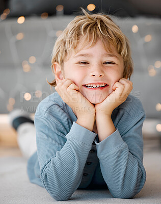 Buy stock photo Portrait smile, boy and lying on floor in home for wellness, relax and alone time with bokeh lights. Face, young child and happy on carpet with healthy gums, clean mouth and dental care for teeth